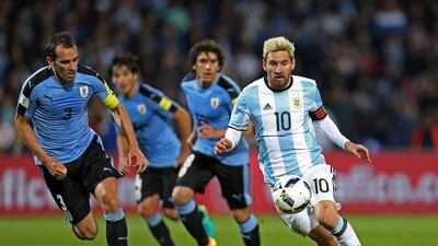Argentina's Lionel Messi, right, vies for the ball with Uruguay's Diego Godin. Nicolas Aguilera / EPA