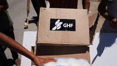 Palestinians carry boxes and bags containing food and humanitarian aid packages delivered by the Gaza Humanitarian Foundation, a U. S. -backed organization approved by Israel, in Khan Younis, southern Gaza Strip, on Thursday, May 29, 2025. (AP Photo / Abdel Kareem Hana)