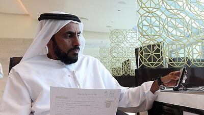 Salem Mohammed Salem Balhuwaimel Al Ameri checks the application after registering for the Federal National Council elections at Al Ain. Satish Kumar / The National
