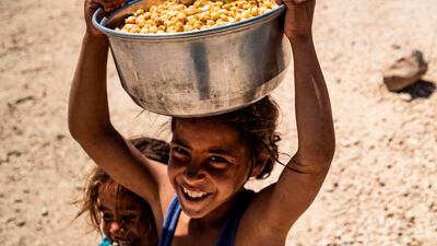 A displaced Syrian girl carries a pot of chickpeas at the Washukanni camp for the internally displaced in Syria's northeastern Hasakeh province, during Ramadan. AFP