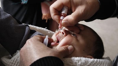 A health worker administers a polio vaccination to a child in Raqqa, eastern Syria. Public health researchers say missing vaccinations contributed to the re-emergence of polio in the area. Nour Fourat / Reuters