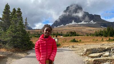 In this photo provided by Ben Pascal, five-year-old Naomi Pascal, holding her teddy bear, is pictured on a hike to Hidden Lake in Glacier National Park, Mont. , in October 2020. Naomi lost the bear while on the hike, but it was found by a park ranger who took care of the bear until it was spotted on the dash of his ranger truck and returned to Naomi this fall. (Ben Pascal via AP)