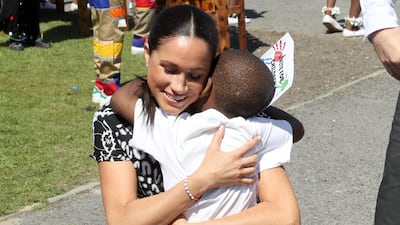 Meghan, Duchess of Sussex receives a hug from a young well-wisher as she visits a Justice Desk initiative in Nyanga township, with Prince Harry, Duke of Sussex, during their African tour in Cape Town, South Africa, on Monday September 23, 2019. Getty Images
