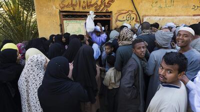 Women and men line up to buy bread at a bakery. Amira, the wife of Salama, leaves her village house shortly after dawn everyday to buy bread at the shop.