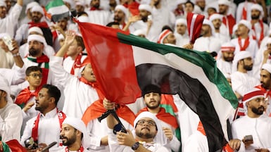 UAE fans fly the flag before the team's qualifying match in Qatar last month. Chris Whiteoak / The National