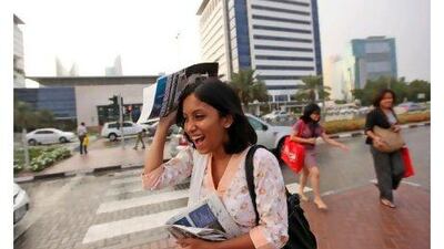 "Oh, it's amazing. It's sudden and sweet," says Mahmuda Sultana, 22, as she shields herself from the rain outside the Dubai World Trade Centre yesterday.
