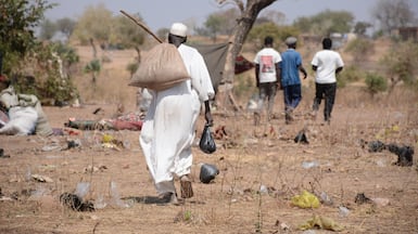 A trudge home with food rations at a displacement camp in Sudan, where civil war has been raging for almost three years. Reuters