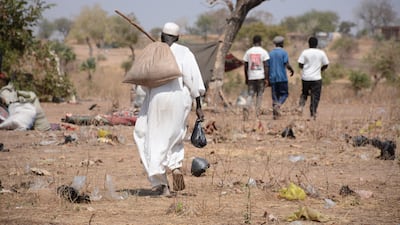 A trudge home with food rations at a displacement camp in Sudan, where civil war has been raging for almost three years. Reuters