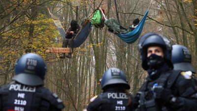 Police officers are seen as demonstrators lie in hammocks hanging from trees during a protest against the extension of the A49 motorway, in a forest near Stadtallendorf, Germany. Reuters