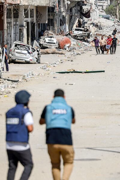 Journalists film while approaching people evacuating an injured woman in Jabalia camp for Palestinian refugees in the northern Gaza Strip. AFP