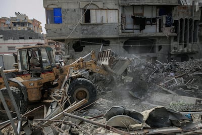 Members of the Egyptian Committee for the Reconstruction of Gaza clear building rubble in Gaza City on May 18. Bloomberg
