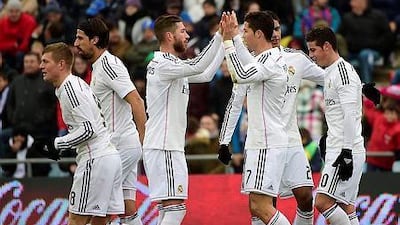 Real Madrid's Cristiano Ronaldo, second from right, celebrates with Real Madrid defender Sergio Ramos after scoring his secnd goal against Getafe at the Coliseum Alfonso Perez stadium in Getafe on January 18, 2015. AFP PHOTO/ PIERRE-PHILIPPE MARCOU