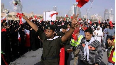 Police officers flowers as they walk with anti-government protesters in in Manama, Bahrain, yesterday.
