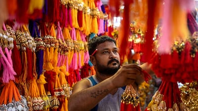 A shopkeeper arranges his display of rakhis in New Delhi. AFP