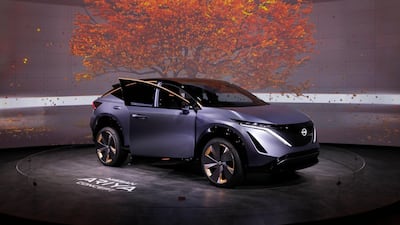 The Nissan Ariya sits beneath virtual leaves. AP