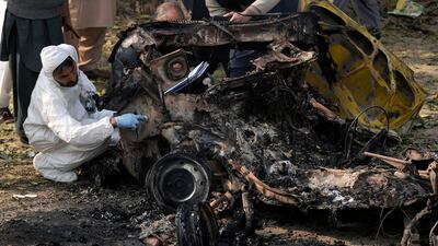 Investigators collect evidence from the wreckage of the car. AP