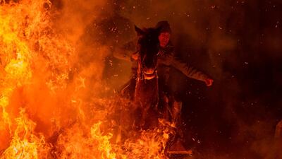 A horseman jumps over a bonfire in the village of San Bartolome de Pinares in the province of Avila in central Spain, during the opening of the traditional religious festival "Luminarias" in honour of San Antonio Abad (Saint Anthony), patron saint of animals. AFP