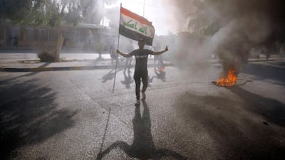 An Iraqi protester holds his national flag during a demonstration in Najaf. AFP