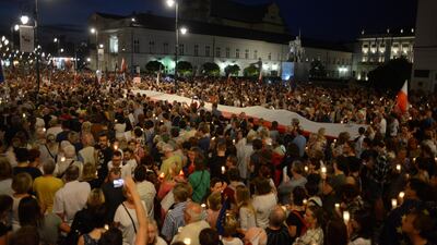 People gather during the 'Chain of lights' protest against judicial overhaul in front of the Presidential Palace in Warsaw. Reuters