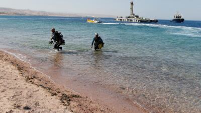 Divers get out of the water after the sinking of military vehicles. Reuters