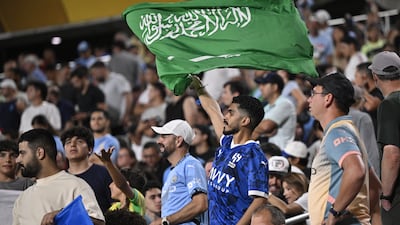 An Al Hilal fan waves a Saudi flag during the match with the English Premier League side. EPA