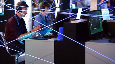 Gamescom visitors play computer games at the booth of Nacon. Henning Kaiser / AFP