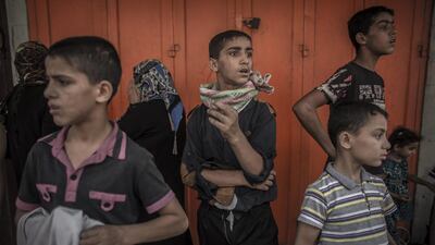 Palestinians boys watch people fleeing from Shuja’iyya neighbourhood in east Gaza City. Oliver Weiken / EPA