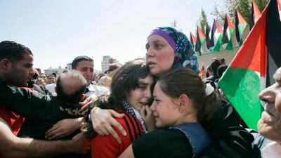 A released Palestinian prisoner embraces her daughters in the West Bank city of Ramallah on Tuesday.