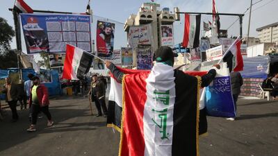 An Iraqi protester clad with the national flag takes part in anti-government demonstrations at Tahrir square in Baghdad. AFP