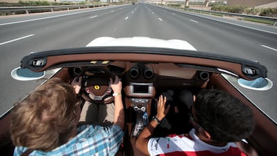 Rob Garratt, left, drives a Ferrari California convertible. Christopher Pike / The National