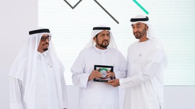 Sheikh Mohamed bin Zayed presents an award to Sultan Bin Rashed Al Dhaheri, on behalf of Sultaco Group for participating in Sandooq Al Watan. Seen with Lt General Dhahi Khalfan Tamim, Chairman of the Board of Directors at Sandooq Al Watan (left). Rashed Al Mansoori / Ministry of Presidential Affairs