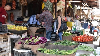 Syrians shop for vegetables at a market in Damascus on Sunday July 11, hours after Syrian President Bashar Al Assad issued a legislative decree granting civil servants and military members a 50 per cent pay rise. The decision comes a day after the government raised the price of fuel by more than 50 per cent for the third time this year. EPA