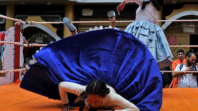 Cholita fighters perform in their signature outfit of pleated skirt, shawl and bowler hat – though this may be understandably discarded during a bout – with pigtail braids. AFP