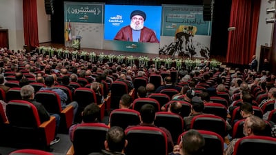 Hezbollah supporters listen to a Martyrs' Day speech by the organisation's leader Hassan Nasrallah on a giant screen in Beirut. EPA/Nabil Mounzer