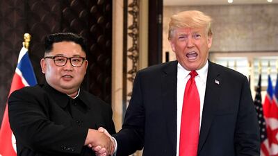(FILES) In this file photo taken on June 12, 2018, US President Donald Trump (R) and North Korea's leader Kim Jong Un shake hands following a signing ceremony during their historic US-North Korea summit, at the Capella Hotel on Sentosa island in Singapore. North Korea has condemned the United States over its latest sanctions measures, warning the policy could "block the path to denuclearization on the Korean peninsula forever". The warning from the North on Sunday, December 16, 2018 came days after the US said it was imposing sanctions on three senior North Korean officials over human rights abuses. / AFP / SAUL LOEB