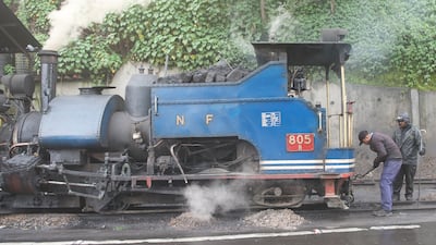 Railway workers prepare a steam engine for its journey along the 90km circuit