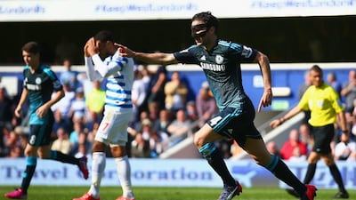 Cesc Fabregas, wearing a protective mask to protect his broken nose, celebrates his winning goal at QPR. Paul Gilham / Getty