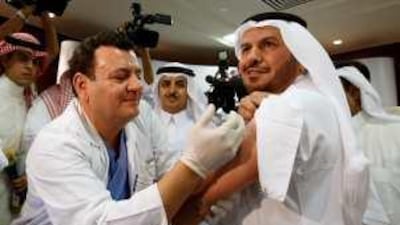 Abdullah al Rabeeah, the Saudi Arabian health minister, right, is injected with the swine flu vaccine in Riyadh this month. He said the kingdom will not ban anyone considered high-risk for the virus from performing the Hajj his year.