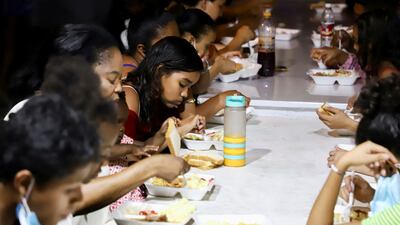 People eat a Christmas dinner of donated food at a shelter in Tapachula, Mexico. Reuters