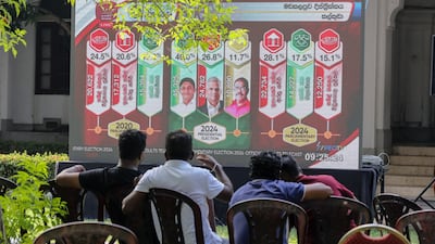 People follow the results Sri Lanka's parliamentary election on a giant screen at a ballot counting centre in Colombo on Friday. EPA