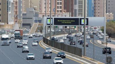 A sign reminds residents to remain vigilant, as they drive along a motorway in Kuwait City. AFP