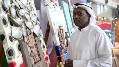 Obaid Suroor with some of his artworks, most of which depict houses or details of traditional buildings. Antonie Robertson / The National