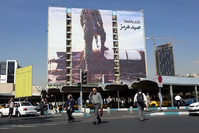 Iranians walk past an anti-US billboard depicting a member of the Islamic Revolutionary Guard Corps in Tehran on Wednesday. EPA