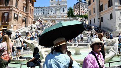 Tourists shield themselves from the sun with hats and umbrellas at the Spanish Steps in Rome, with much of Europe in the grip of an early-season heatwave. AFP