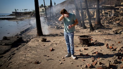 Resident Luke Dexter sifts through the remains of his family's fire-ravaged beachfront property in the aftermath of the Palisades fire. AP Photo