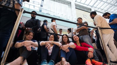 Apple customers queue through the night to be one of the first to get the new Apple devices. Leslie Pableo / The National