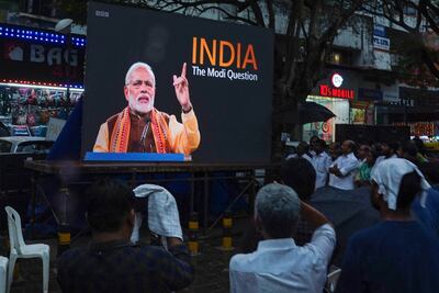 People watch the BBC documentary 'India: The Modi Question', on a screen installed at the Marine Drive junction in Kochi. AFP