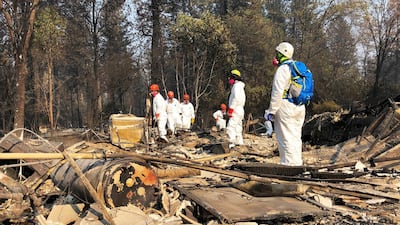 A search and rescue team search for bodies in the ruins of a home in Paradise, California, following the recent wildfire. Sudhin Thanawala / AP