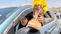 A Lebanese woman travels south carrying yellow roses representing her son, who was killed by the Israeli military. The National