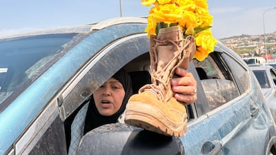 A Lebanese woman travels south carrying yellow roses representing her son, who was killed by the Israeli military. The National